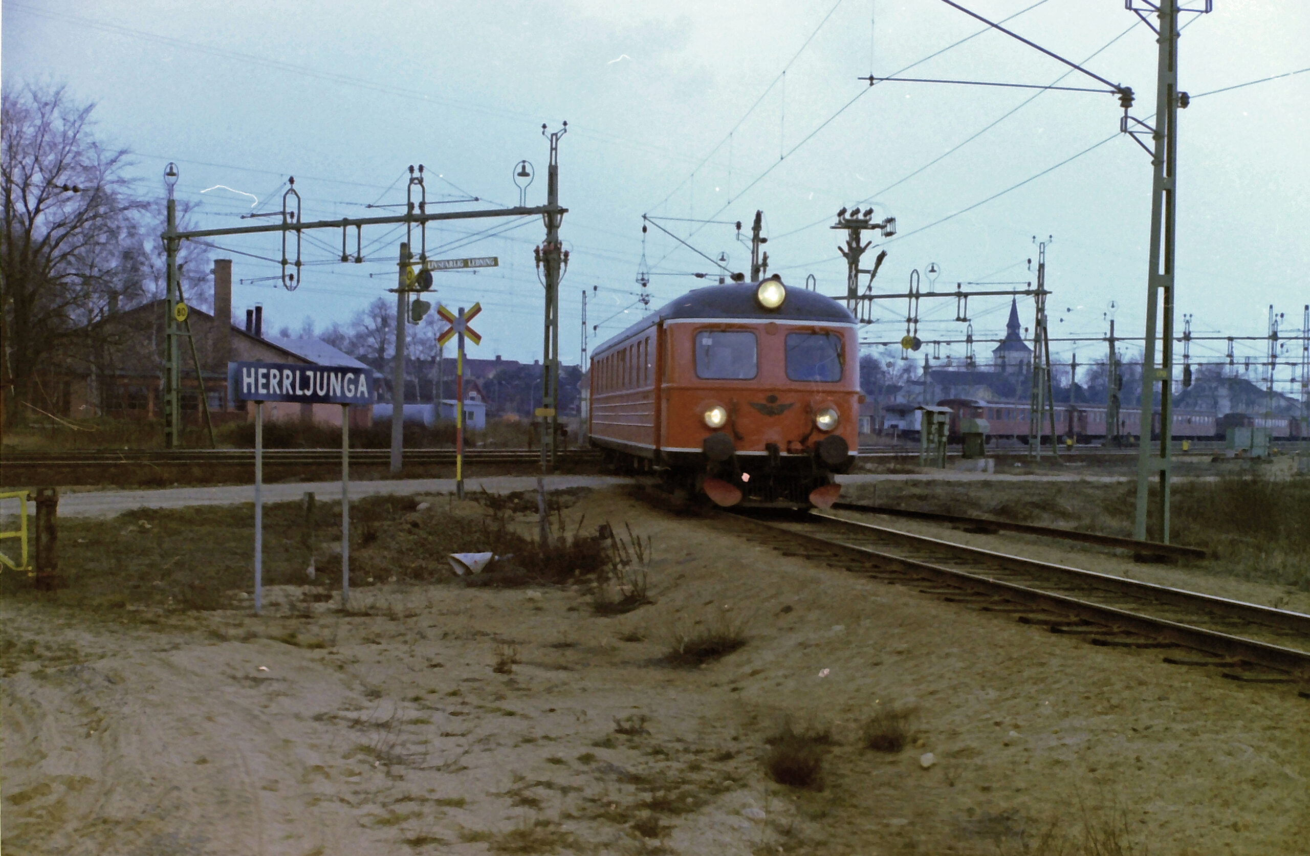 Ett X8-tåg är på väg att lämna Herrljunga över det gamla spårkrysset på sin färd mot Uddevalla i mars 1976. Foto: Christer Hagman.